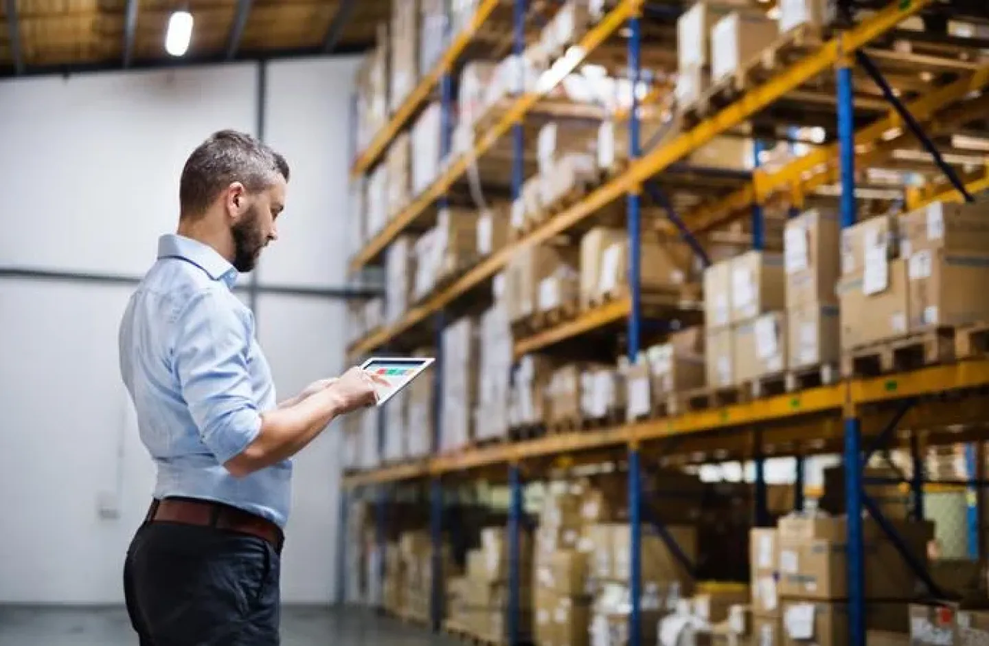 A warehouse manager using technology to manage his warehouse.